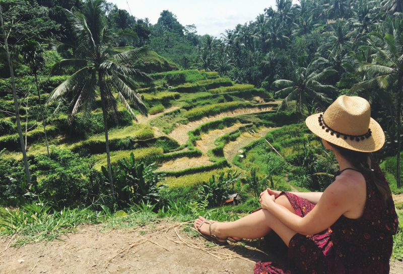 Woman in hat admires the rows of the beautiful Tegallalang Rice Terraces in Ubud, Bali